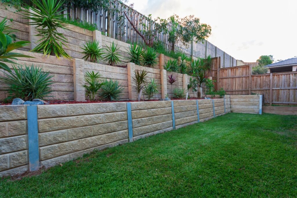 A backyard with a retaining wall adorned with beautiful landscaping.