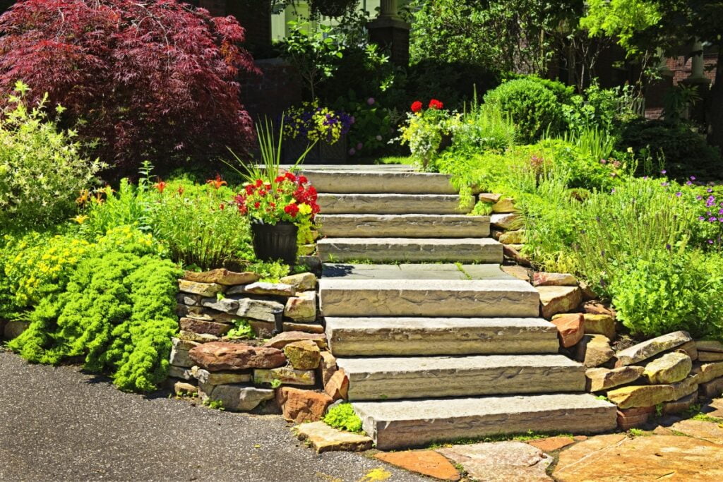 A stone stairway serving as a retaining wall for a garden landscaping.