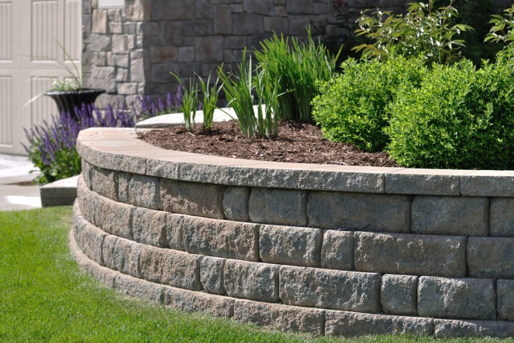 A stone landscaping feature in front of a house.