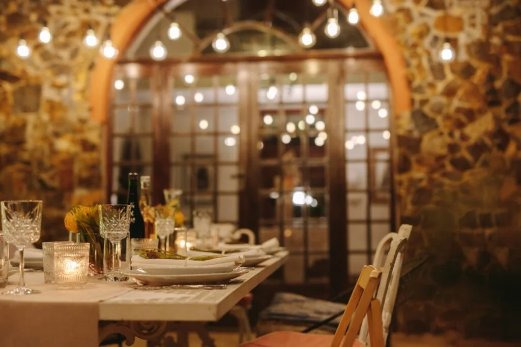 A dinner party table is set on a backyard patio.