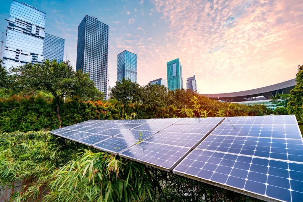 Solar panels on a rooftop in front of a city skyline showcasing an innovative landscape architecture trend.