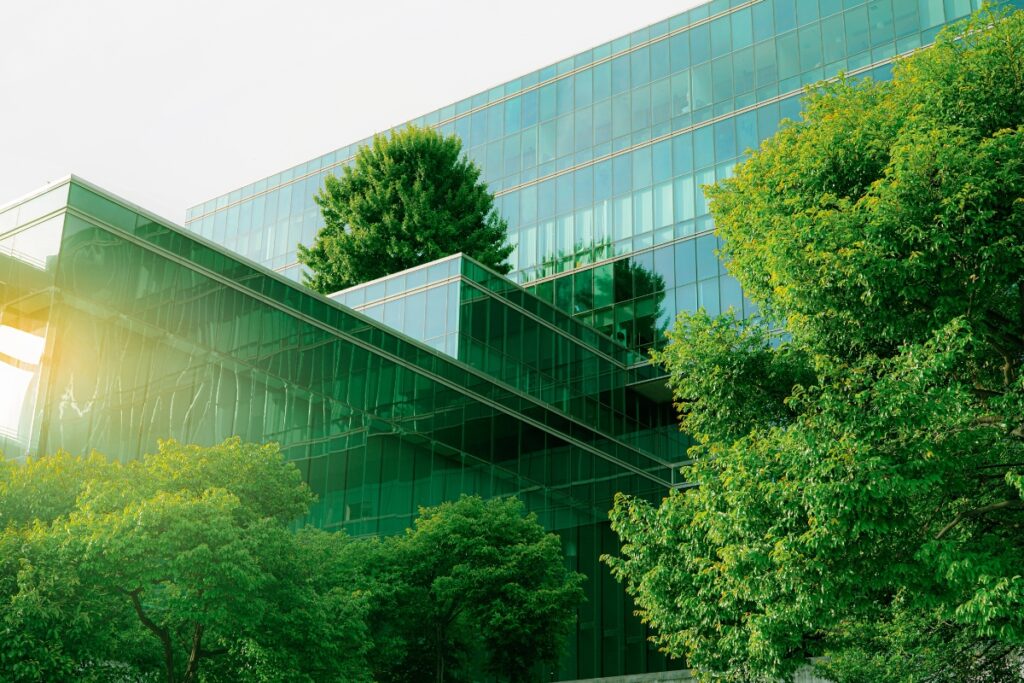 A green building surrounded by trees, showcasing the latest Landscape Architecture Trends.