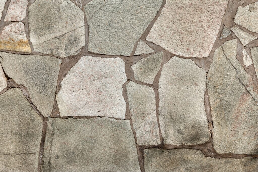 A close up of a stone wall, building a garden path.