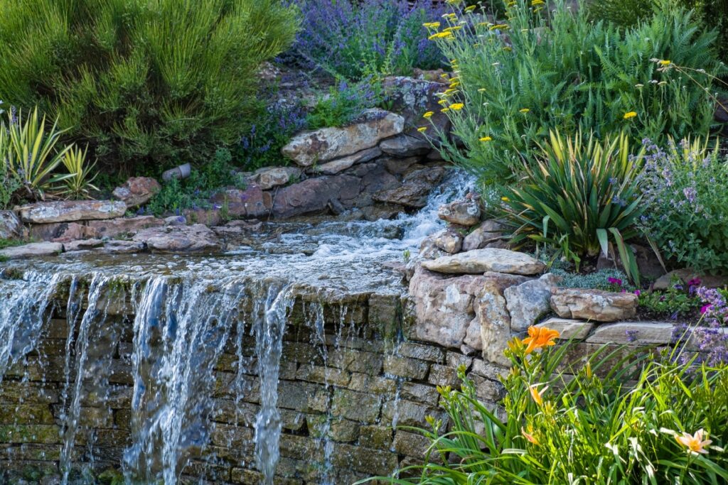 Building a garden path that leads to a waterfall surrounded by rocks and flowers.