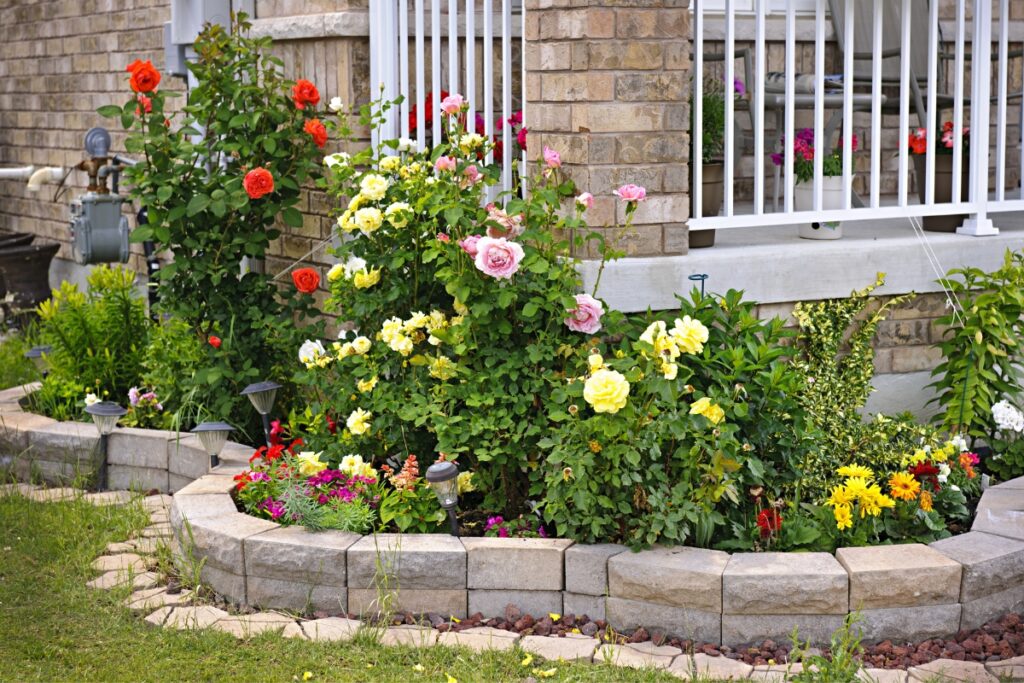 Garden Stone Border: Elevate Your Outdoor Space with Timeless Elegance 6 A garden with a stone border in front of a house.
