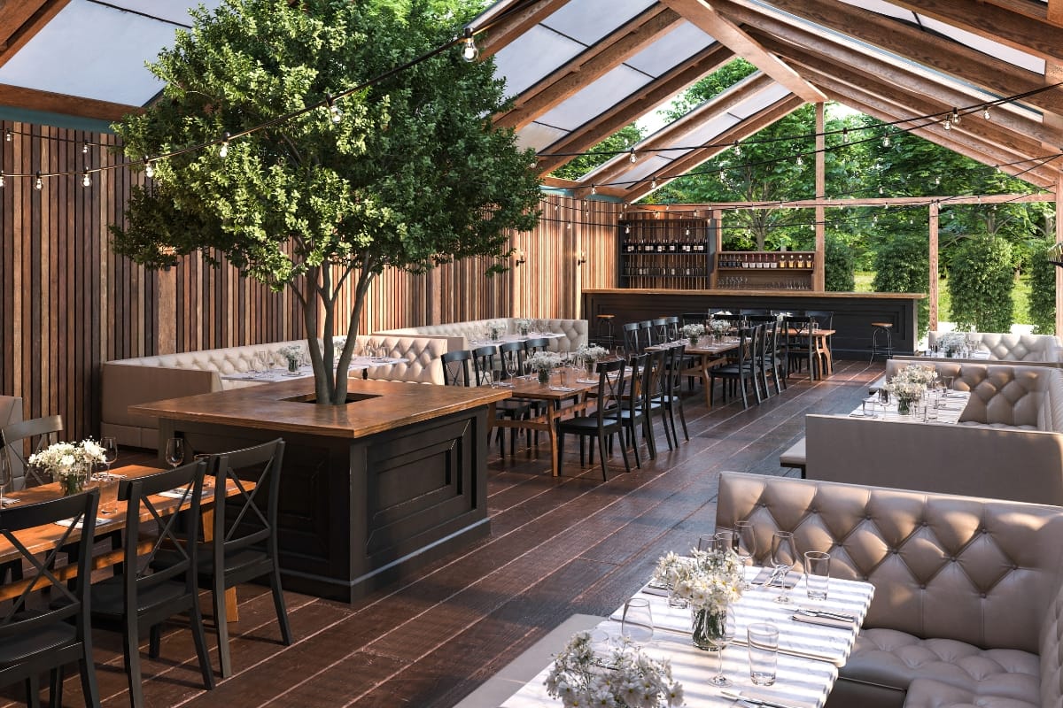 Outdoor Living Spaces in Woodstock: A Must for Local Businesses 6 Open-air restaurant with wooden beams, glass ceiling, potted tree, cushioned seating, and set tables with flowers, surrounded by greenery—perfect for those who appreciate stylish outdoor living spaces.