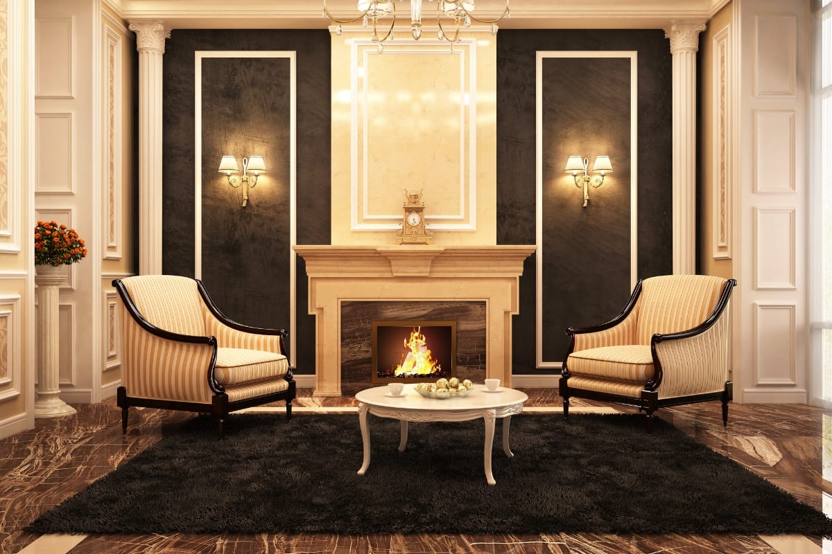 Fire Features in Buckhead: Why Commercial Spaces Should Invest 5 Elegant living room with a marble fireplace showcasing stunning fire features, two striped armchairs, a round coffee table, wall sconces, and a black rug on a marble floor.
