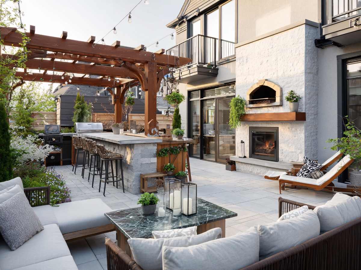 How Outdoor Fire Features in Atlanta Make Business Spaces More Inviting 2 Modern backyard patio with a pergola, bar seating, outdoor kitchen, lounge area, string lights, fireplace, and pizza oven—perfect for enjoying Outdoor Fire Features in Atlanta beside your home.